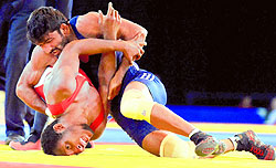 India's Yogeshwar Dutt pins down Canada's Jevon Balfour during their 65kg final bout in Glasgow on Thursday