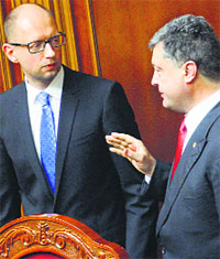 Ukrainian President Petro Poroshenko (R) speaks to Prime Minister Arseniy Yatsenyuk at Parliament in Kiev.