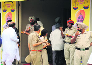 Policemen enjoy sweets outside SAD candidate Jeet Mohinder Singhs election office in Talwandi Sabo on Friday.