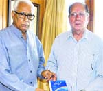 Poet and writer Ghulam Nabi Khayal presents a copy of 'Kashmir Ki Waadi' to Governor NN Vohra at Raj Bhawan in Srinagar on Friday. A Tribune photograph