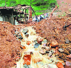 Villagers watch a rescue operation at the site of the landslide at Malin village in Pune district on Friday.