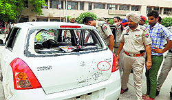 Police personnel examine the car in which the boy (inset) was sitting when a bullet hit him outside Muktsar Government College on Friday