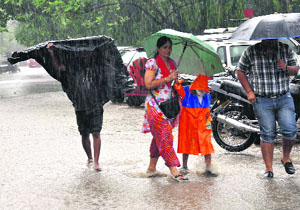 People drenched in heavy rain in Dehradun on Friday.