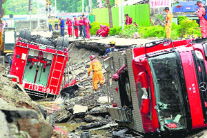 Rescue workers use a sniffer dog to look for missing persons believed to be buried as firetrucks lie damaged after massive gas explosions in Kaohsiung, Taiwan, on Friday.