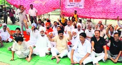 Congress workers stage a protest demanding construction of an overbridge near the Patiala Phatak in Bathinda on Saturday. Tribune photo
