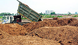 A dumper puts soil on heaps of garbage at a dumping yard in Sector 74, Mohali