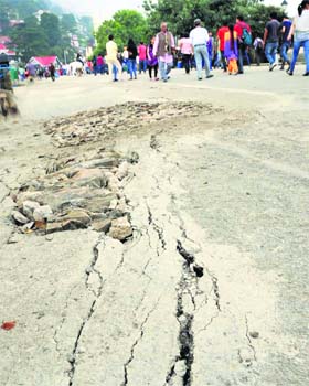 Seasonal pangs: People walk near the cracks that appeared on The Ridge after heavy rainfall on Saturday