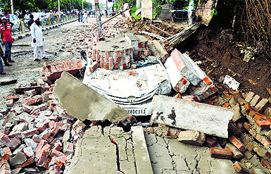 A car was buried in the debris after a wall of the Civil Hospital collapsed during rain in Ludhiana on Saturday. 
