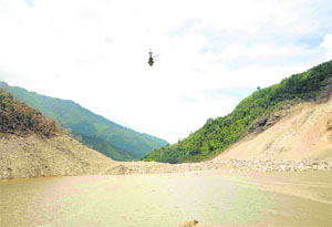 A helicopter belonging to the Nepal Army hovers over the swollen Kosi River on Saturday.