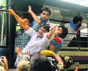 Police detain NSUI members during a protest in front of residence of Union Home Minister Rajnath Singh in New Delhi on Saturday.