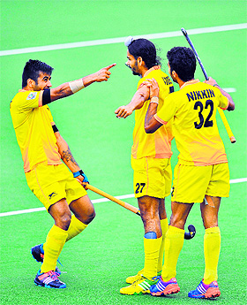 Akashdeep Singh (C) celebrates a goal with Manpreet Singh (L) during their semifinal clash against New Zealand in Glasgow on Saturday. 