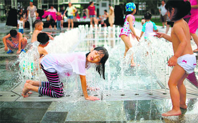 Children play in a fountain to keep cool on a hot summer day in Shanghai
