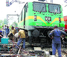 Workers try to put the engine back on rails
