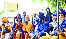 Brandishing lathis, SGPC supporters guard Chhevin Patshahi Gurdwara in Kurukshetra on Sunday