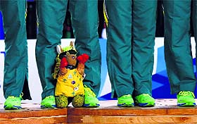 Australias netball team mascot sits on the podium as the team waits to receive their gold medals.