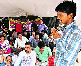 A leader addresses contractual polytechnic teachers sitting on a dharna in Dehradun on Sunday.