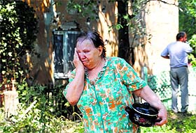 A woman cries after her home was damaged during shelling on the outskirts of the Ukrainian city of Donetsk on Sunday.