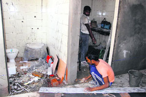Labourers work in the bathroom of the hostel block where girls are being accommodated. 