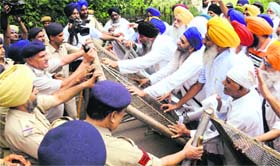 Members of the United Sikh Movement try to cross barricades near Sukhna Lake in Chandigarh on Monday.