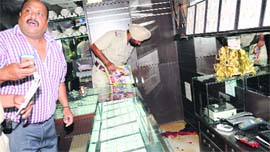 A police official examines the crime spot at KRJ Karan Jewellers in Sector 22 on Monday.