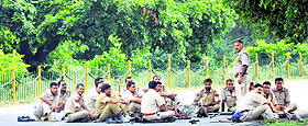 policemen take a break after HSGMC supporters staged a protest near the gurdwara on Monday