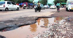 Water accumulated on a potholed road near Majri Chowk in Panchkula. Tribune Photo: Nitin Mittal