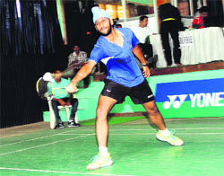 A player tries to play back the shuttle during a match in the All India Ranking Badminton Tournament at the multi-purpose sports hall in Dehradun on Tuesday.