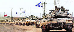Israeli Merkava tanks drive near the border between Israel and the Gaza Strip as they return from the Hamas-controlled Palestinian coastal enclave on Tuesday