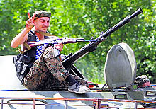 A Ukrainian serviceman gestures while driving past a military armoured vehicle in Kramatorsk on Tuesday