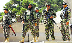 Afghan soldiers keep watch at the gate of a British-run military training academy, Camp Qargha, in Kabul on Tuesday