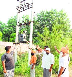 People show the transformer from where three youths were electrocuted in Kotla Gujra village in Majitha in Amritsar on Wednesday