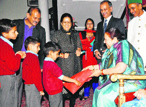 Governor  Urmila Singh distributes woollen clothes to children at the Raj Bhawan in Shimla on Wednesday.