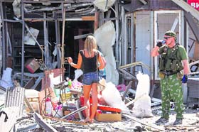 A pro-Russian separatist and a woman stand near a damaged building following what locals say was a recent airstrike by Ukrainian forces in Donetsk on Wednesday