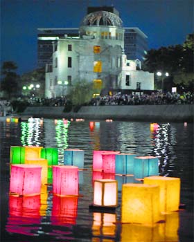 69th anniversary of 1st atomic attack: Paper lanterns float in the Motoyasu River in front of the Atomic Bomb Dome (background) at the Peace Memorial Park in Hiroshima on Wednesday