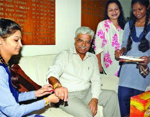 An underprivileged girl ties Rakhi on the wrist of Delhi Police Commissioner B.S. Bassi as part of a social campaign for marginalized children to mark Raksha Bandhan at PHQ in New Delhi on Thursday.
