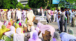 Residents of Buraj Gohran village hold a protest by keeping a farmers body (in glass box) on the road near the district administrative complex in Sangrur on Thursday