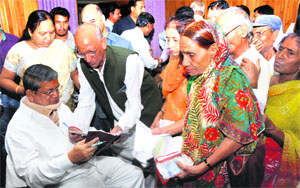 Chief Minister Harish Rawat listens to the grievances of people in Dehradun on Thursday.