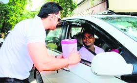 To encourage people towards making the city clean and green, a college student distributes car bins in Jalandhar on Friday.