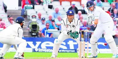 MS Dhoni looks on as Joe Root plays a shot during the second day of the fourth Test match at Old Trafford on Friday. AFP