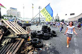 People walk past a barricade erected by protesters at Independence Square in central Kiev on Friday.
