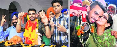 Arpinder Singh, who won India its third medal in athletics in the mens triple jump event at the 20th Commonwealth Games, shows his medal; (right) Arpinder being kissed by his mother Harmeet Kaur in Amritsar on Saturday. Photo: RK Soni