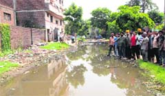 Residents show a road inundated with rain water at the Industrial Area located on the Maqboolpura Road in Amritsar. Photo: Vishal Kumar