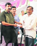 Industries Minister Mukesh Agnihotri gives away a cheque from the CM Relief Fund to a beneficiary in Haroli on Saturday.