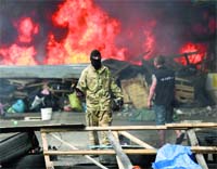 A protester holds a petrol bomb as he tries to prevent municipal workers from clearing away barricades and tents 