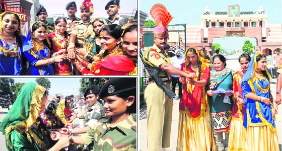 Knot of love: Girls dressed in traditional attire tie rakhi on the wrist of Border Security Force (BSF) soldiers at the India-Pakistan joint checkpost in Attari on Sunday