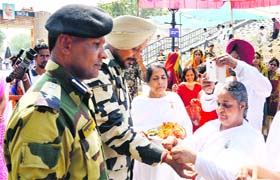 Responsible brothers: A member of the spiritual cult Brahma Kumaris tie a rakhi on the wrist of Border Security Force (BSF) Company Commander Jaswinder Kang at the India-Pakistan joint check-post in Attari