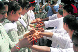Girls tie rakhis on the wrists of boys during the Raksha Bandhan festival on the Ridge in Shimla on Sunday.