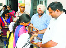 Workers of the AAP tie Rakhi on the wrist of policemen in Ludhiana