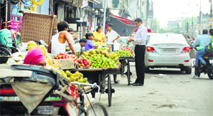 Vegetable and fruit vendors do business on a roadside.