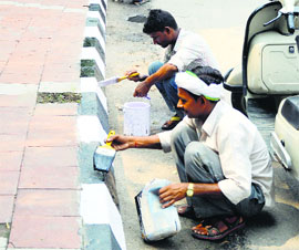 Workers give final touches to a footpath near Rakh Bagh in Ludhiana.
